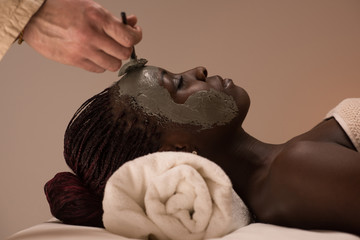 African woman having clay facial mask