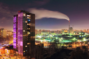 Fototapeta premium The smoke from industrial pipe in the city at night