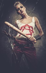 Punk girl behind broken glass with a baseball bat
