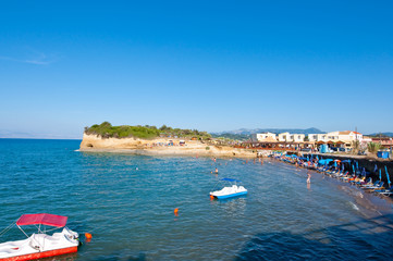 Sidary sandy beach, people sunbath on the shore. Corfu, Greece.