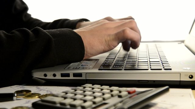 hands typing on the computer and make calculations on a calculat