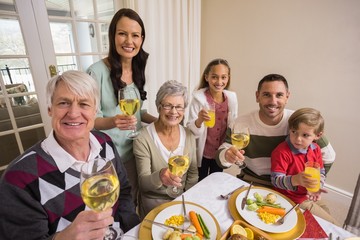Smiling family toasting to camera during christmas dinner