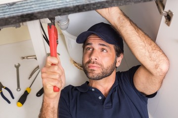 Plumber fixing under the sink