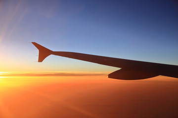 Obraz premium Sunset sky and airplanes wing view out of the window