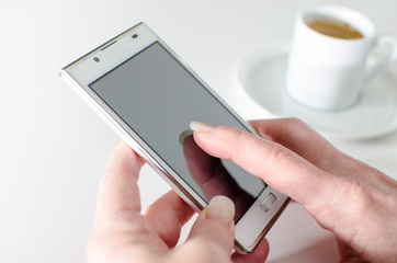 Businesswoman using a smartphone during coffee break
