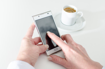 Businesswoman using a smartphone during coffee break