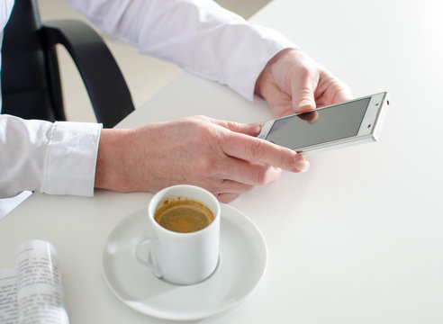 Businesswoman using a smartphone during coffee break