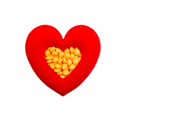 pills in red heart shaped box isolated on white background