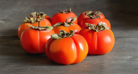 Ripe orange persimmon on the wooden background