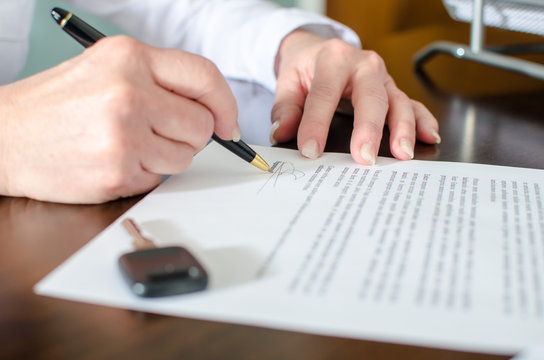 Woman signing a car purchase contract