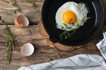 Scrambled eggs in an iron pan on the rustic table