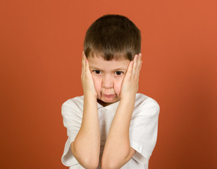 grimacing boy portrait on brown