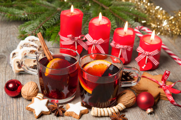 Fototapeta na wymiar Red mulled wine on table with burning candles