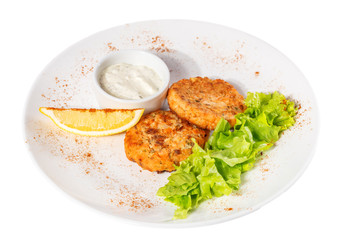 Cutlets with salad leaves, sauce and lemon