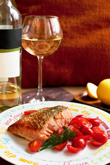 Homemade baked salmon with cherry tomatoes and glass of white wi