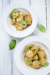 Above view of ravioli with pesto sauce in glass plates, close-up