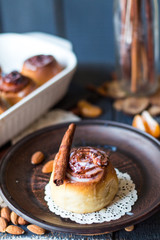 Cinnabon cinnamon rolls, almonds and mandarins on a dark plate