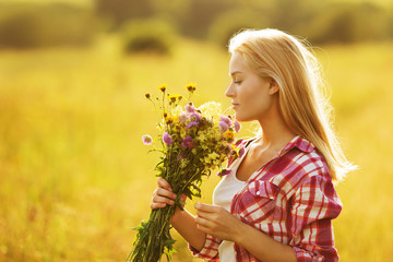 Happy girl with a bouquet of wildflowers