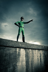 Superhero pointing with dramatic background