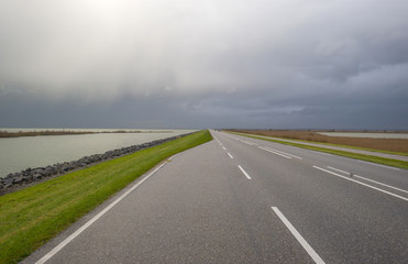 Road on a dike along a lake in autumn