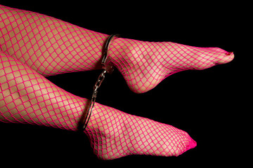 Woman legs in pink cuffs on black close