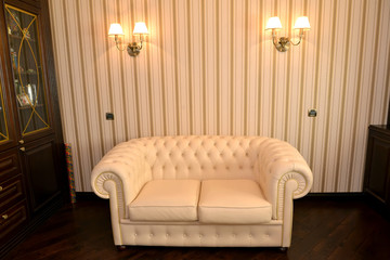 Obraz premium Fragment of an interior of a house office with a white sofa