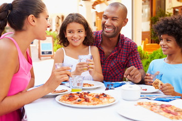 Family Eating Meal At Outdoor Restaurant Together