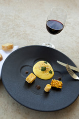 Egg with corn and polenta, glass of red wine