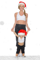 Obraz premium woman with child in snow in Santa hats