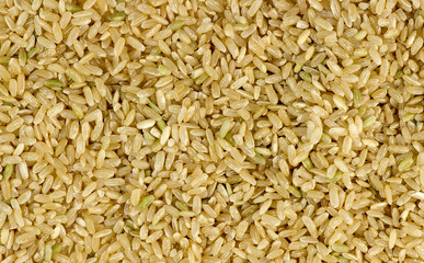Overhead macro shot of uncooked raw brown rice background textur