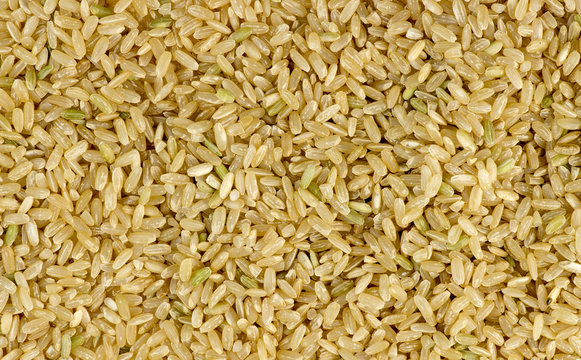 Overhead macro shot of uncooked raw brown rice background textur