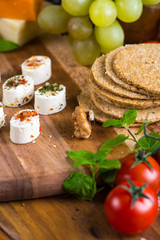 selection of soft cheese with fruits, spices and meat