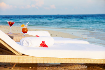 Loungers At Edge Of Tropical Sea With Cocktails