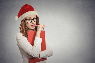 woman with christmas hat thinking of gift ideas grey background 