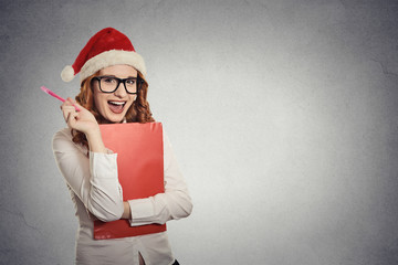 woman with christmas hat thinking of gift ideas grey background 