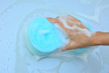 Fototapeta premium female hand is cleaning car bonnet with blue sponge