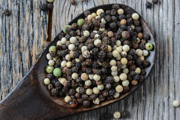 black ,white, green, brown peppercorns on rustic wooden table