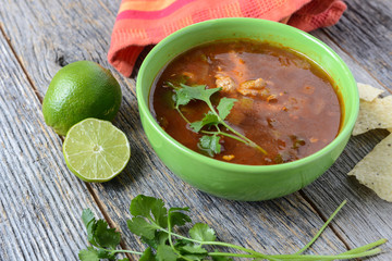 Tortilla Soup with Chips, fresh lime and cilantro on Rustic Wood