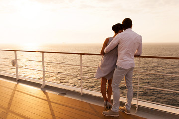 young couple hugging at sunset on cruise ship - obrazy, fototapety, plakaty
