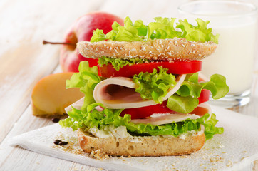 Sandwich with  milk and apple  on   wooden table