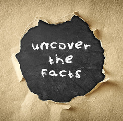 top view of blackboard with the phrase uncover the facts