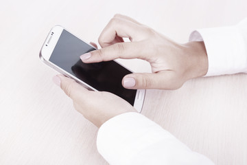 Woman using smartphone on light background