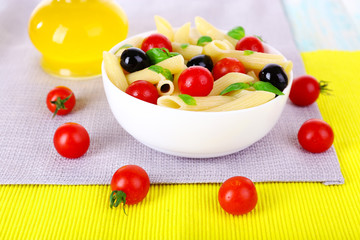 Fototapeta na wymiar Pasta with tomatoes, olives, olive oil and basil leaves in bowl
