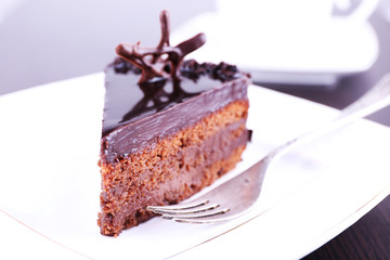 Delicious chocolate cake on plate on table