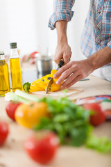 closeup on man's hands cutting vegetables