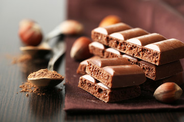 Tasty porous chocolate with nuts on table, close up