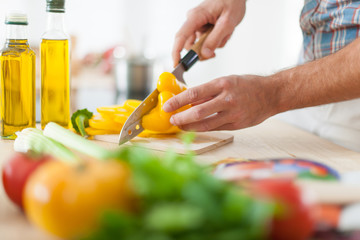 closeup on man's hands cutting vegetables