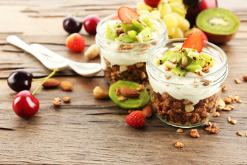 Healthy layered dessert with muesli and fruits on table