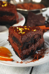 Chocolate cake with chocolate cream on wooden table close-up