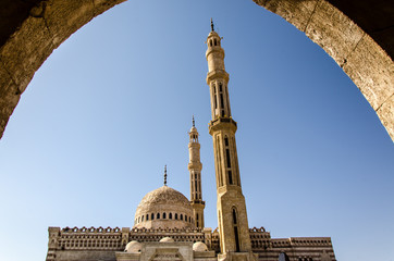 Fototapeta premium Blick durch Bogen auf Minarett und Moschee im Sinai
